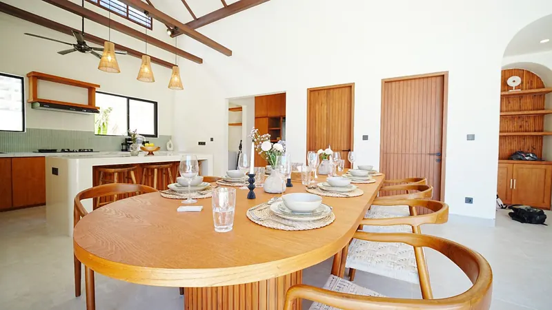 Oval dining table beneath woven rattan pendant lights in a Bali villa